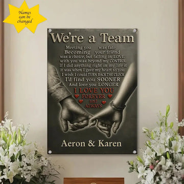 Decorative wall sign with hands holding text 'We're a Team' and personalized names 'Aeron & Karen' on a neutral background.