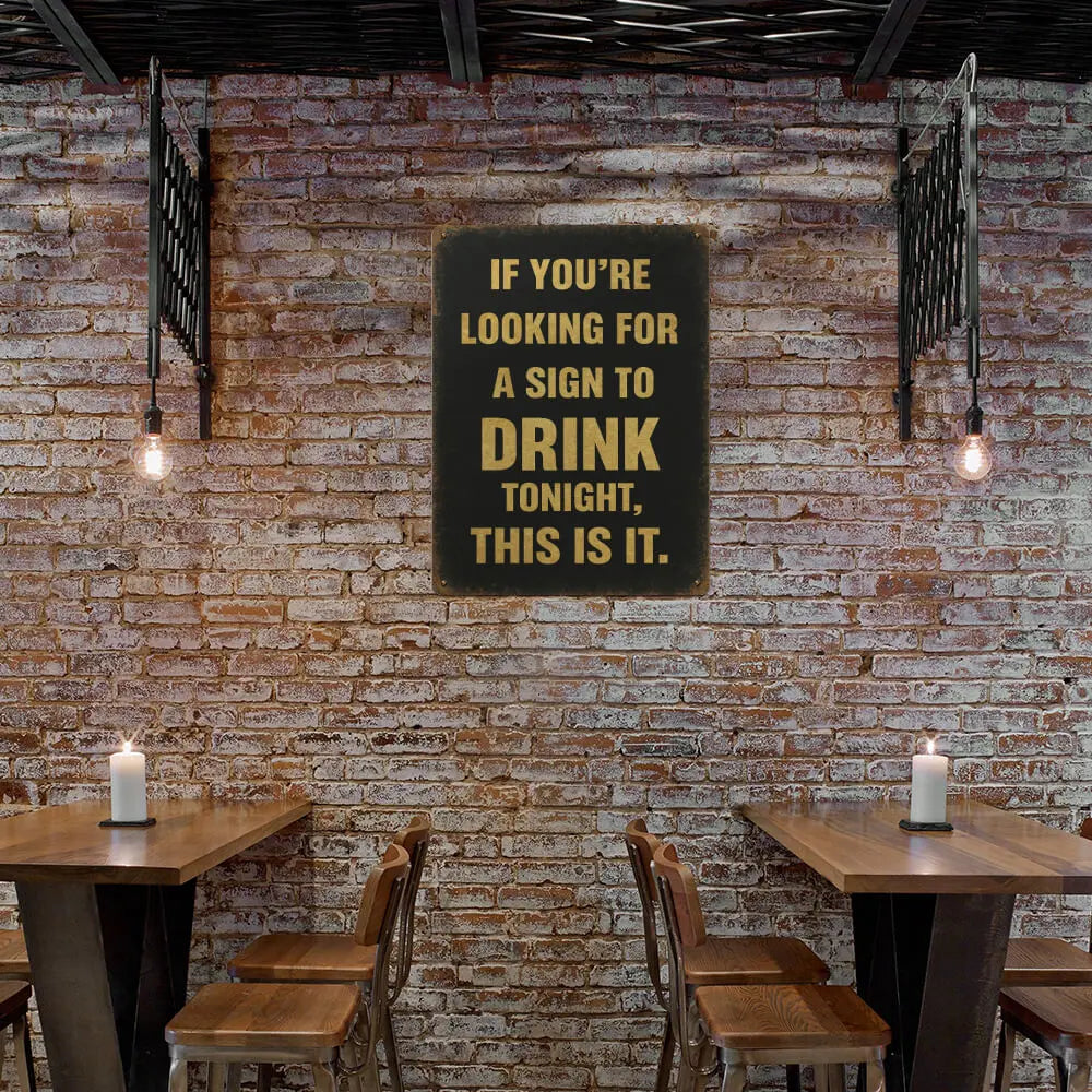 Brick wall with a sign and wooden tables and chairs.