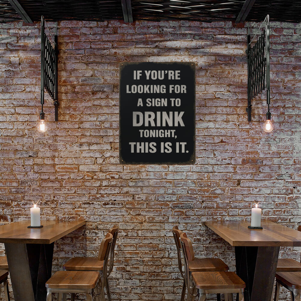 Brick wall with a sign and wooden tables and chairs.