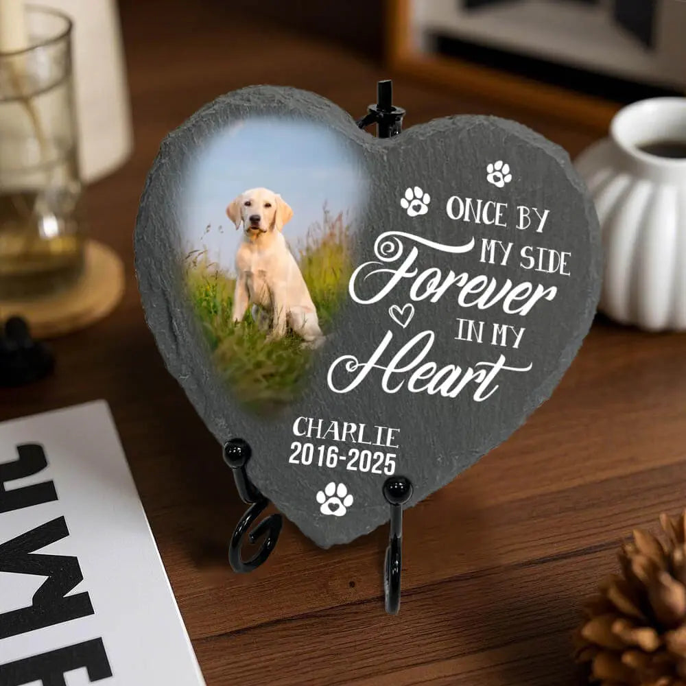 Heart-shaped pet memorial with a photo of a dog and text on a wooden surface.