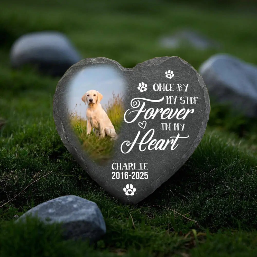 Heart-shaped pet memorial stone with a dog's photo and text on grass