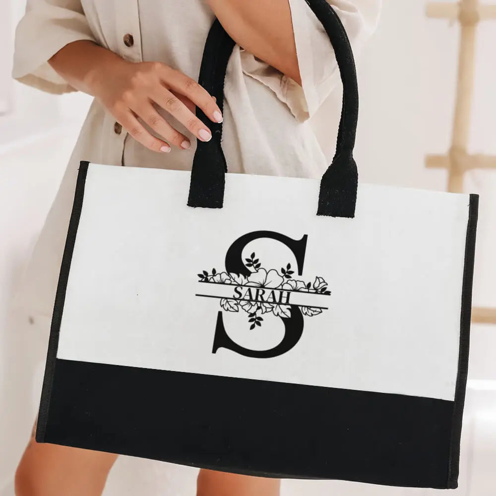 Woman holding personalized initial canvas tote bag with custom name, chic everyday bag for work or beach
