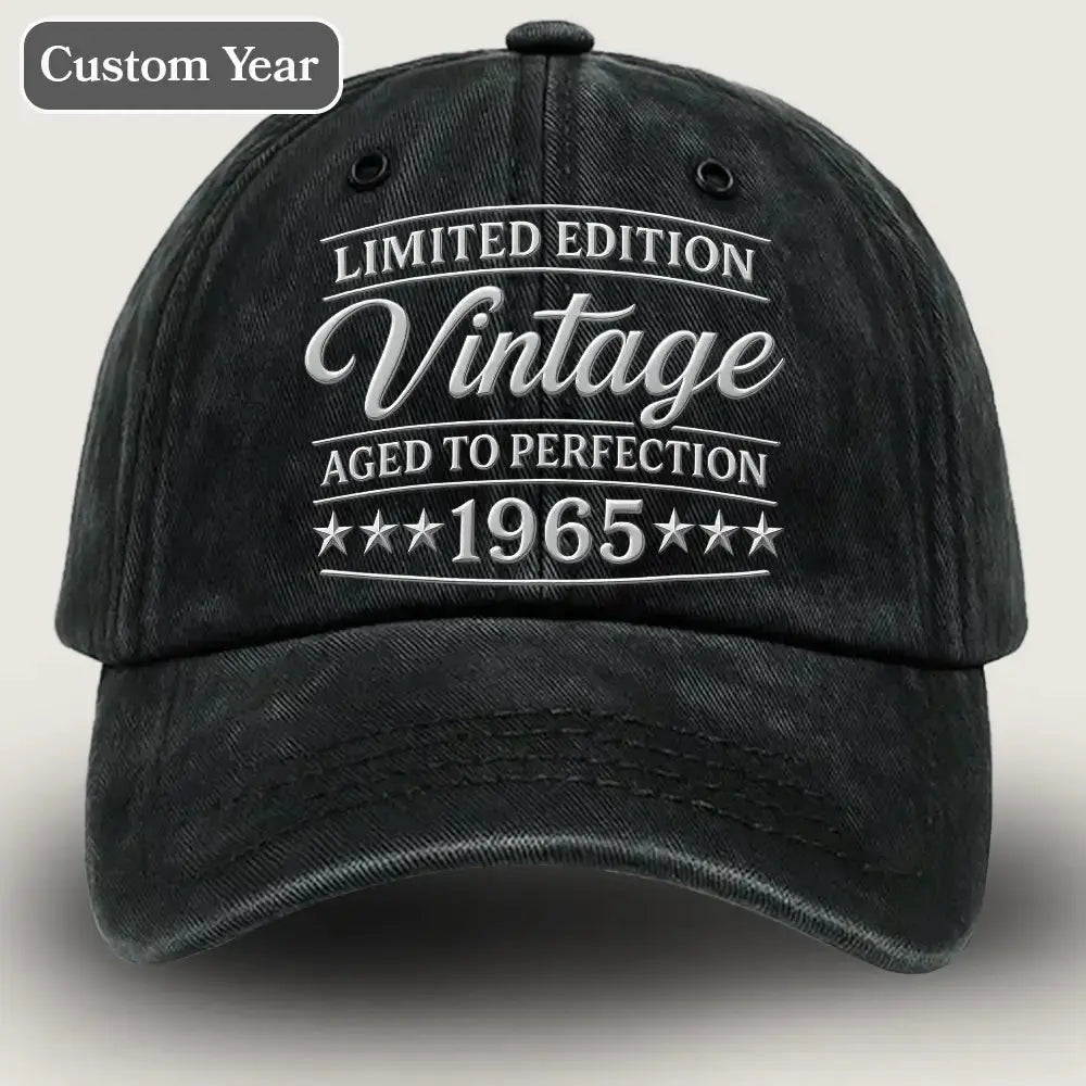 Black cap with white text 'Limited Edition Vintage Aged to Perfection 1965' on a beige background