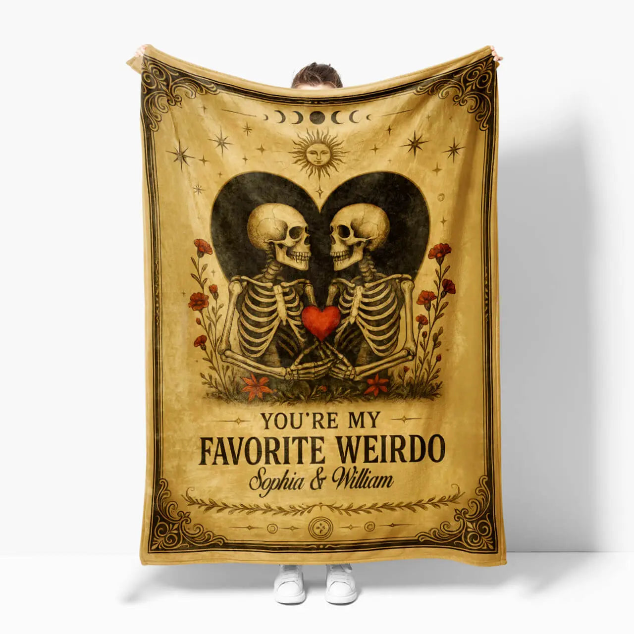 Blanket with skeleton design and text 'You're my favorite weirdo' held by a person on a white background