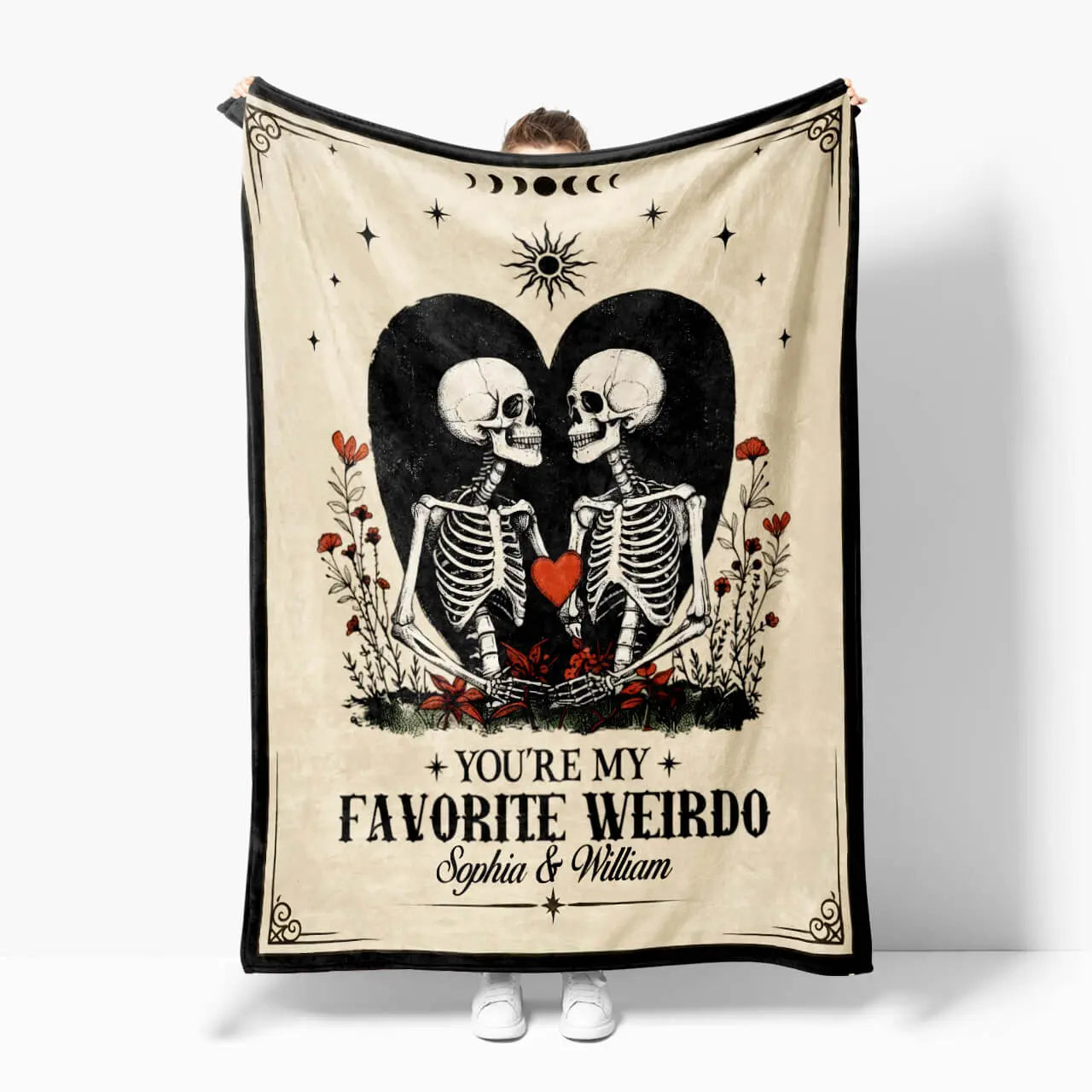 Blanket with skeletons holding hearts and text 'You're my favorite weirdo' on a white background